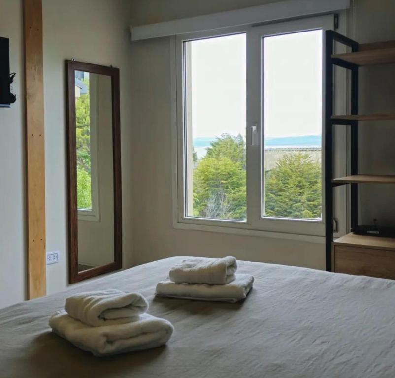 2 toallas en una cama en una habitación con ventanas en Ushuaia Suites Connect Point 2, en Ushuaia