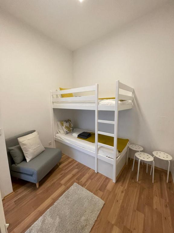 ein kleines Zimmer mit einem Etagenbett und einer Couch in der Unterkunft Central Mini Apartment RHG 1 in Wien