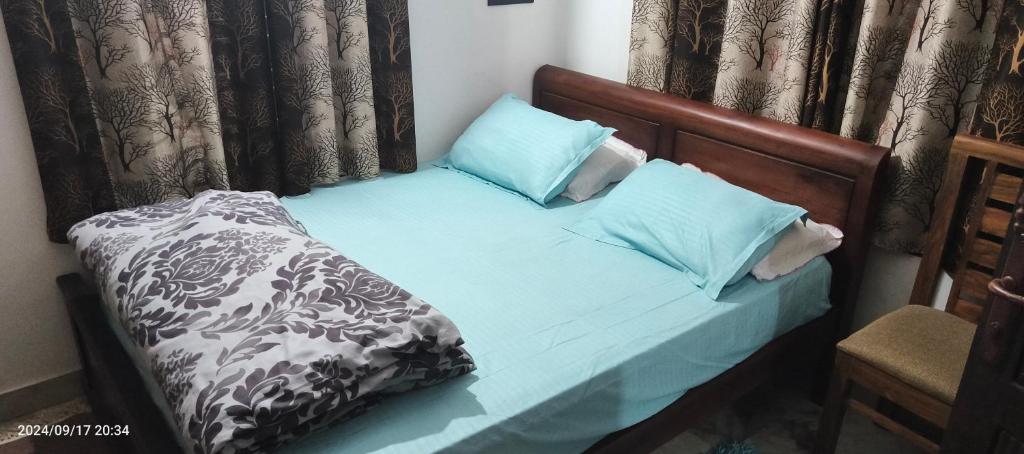 a small bed with blue pillows on it at Blue mount stay in Gūdalūr