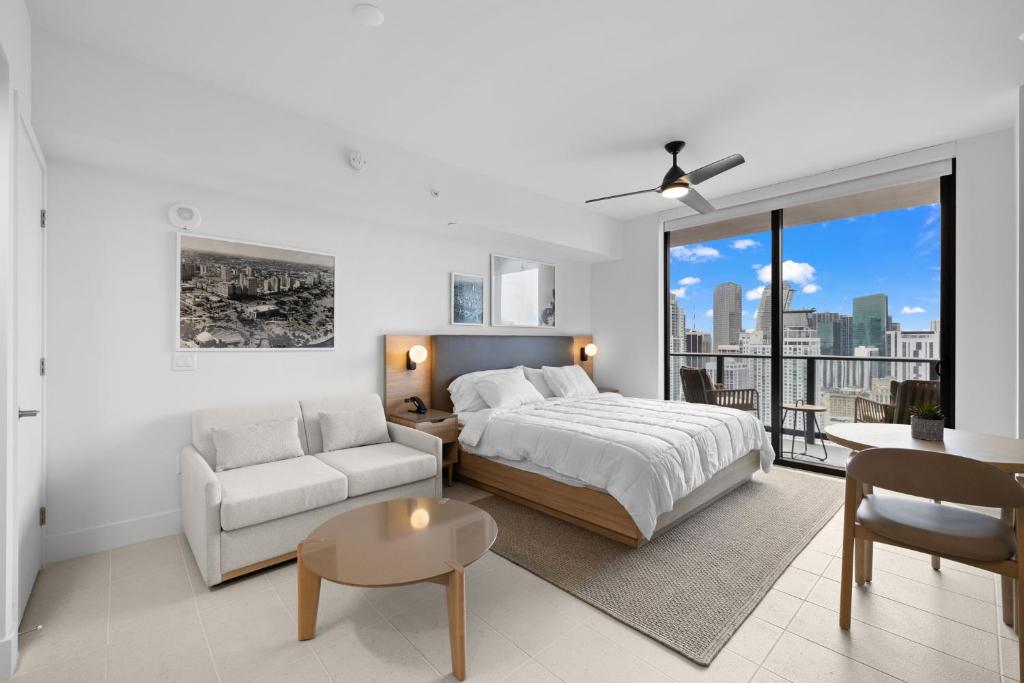 a bedroom with a bed and a couch and a table at Ultimate Elegance Studio with Panoramic City Views in Miami