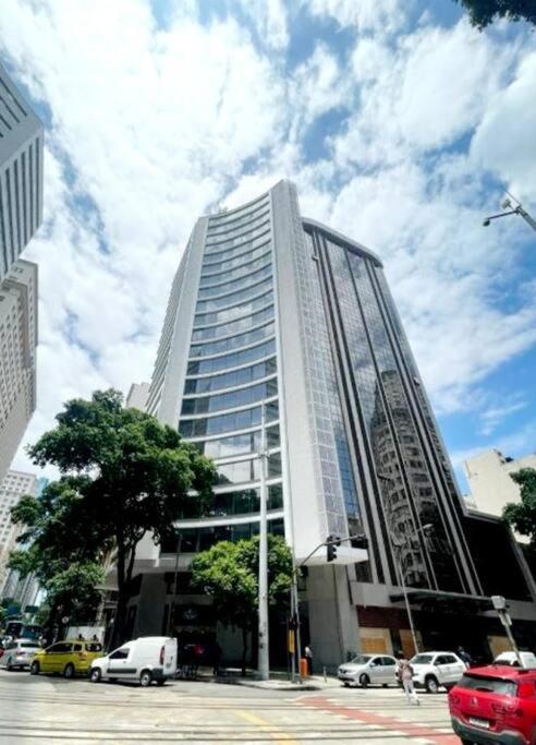 a tall building with cars parked in front of it at Flat Moderno no Coração do Rio in Rio de Janeiro
