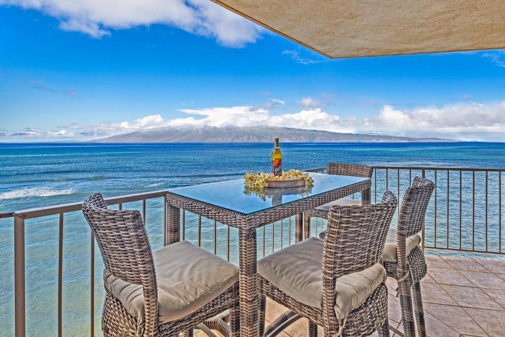 a table and chairs on a balcony with the ocean at Royal Kahana 1010 in Kahana