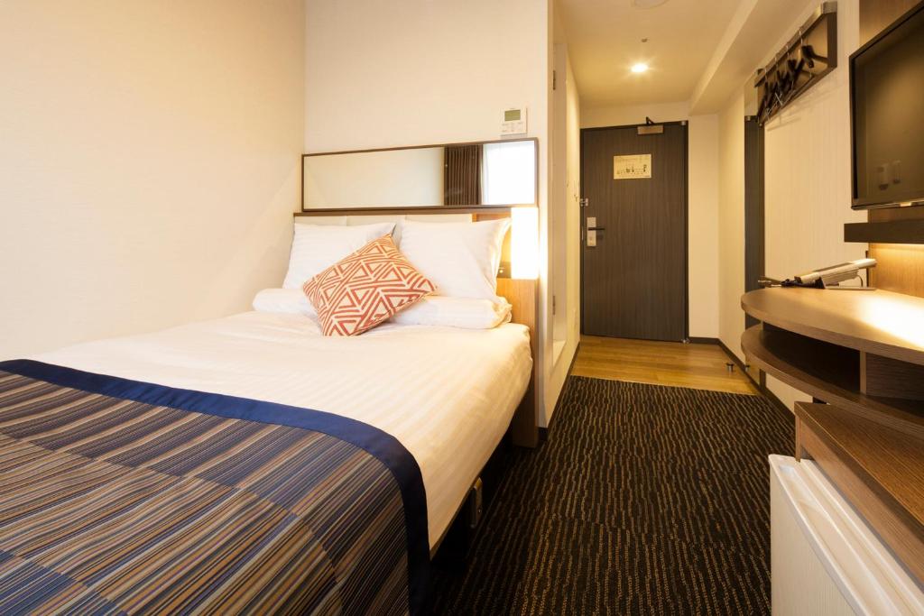 a hotel room with a bed and a sink at Hotel Mystays Gotanda Station in Tokyo