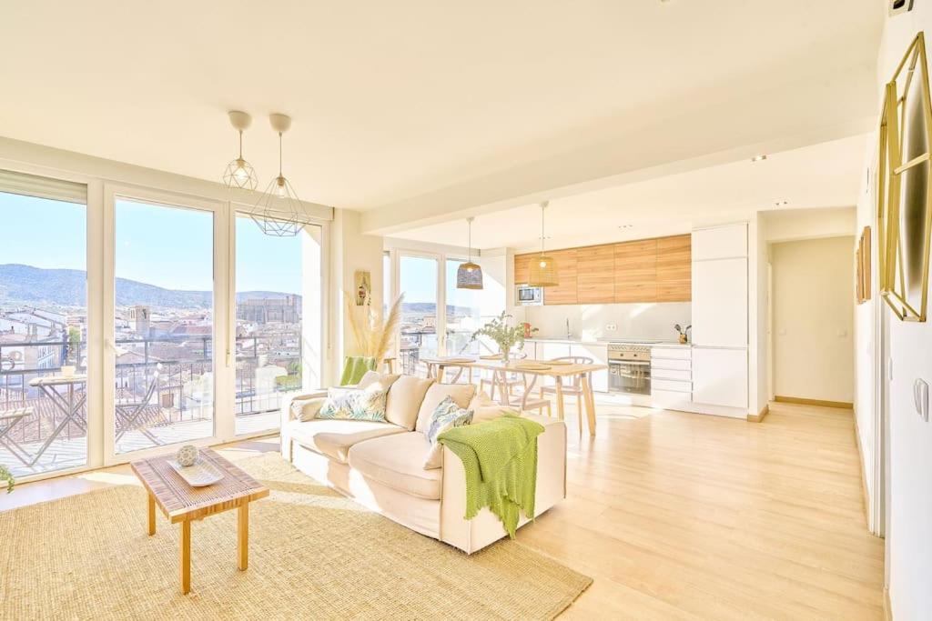 un salon avec un canapé blanc et une cuisine dans l'établissement El mirador de Plasencia by keyhom, à Plasence