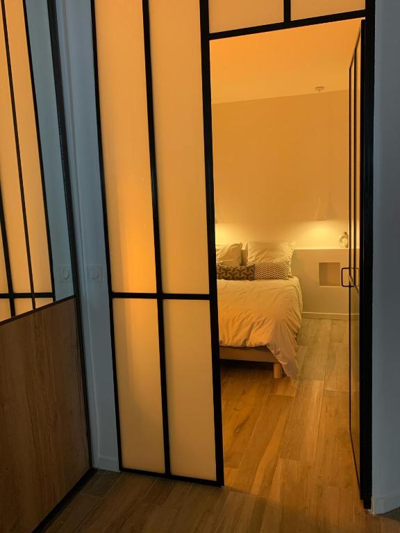 une chambre avec un lit et une porte coulissante en verre dans l'établissement Au coeur du vieil Antibes, à Antibes