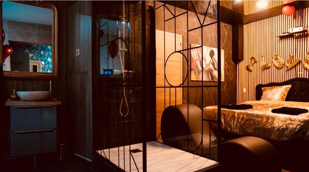 Un dormitorio con una cama y una pared de cristal. en Loveroom 50 nuances de bulles jacuzzi et sauna privatif, en Lens