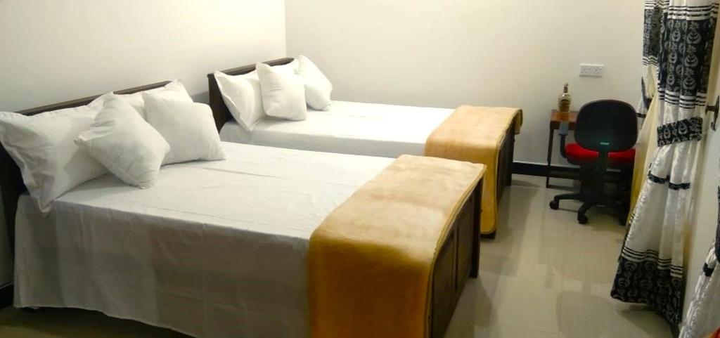 a hotel room with two beds and a couch at Githu Rest in Anuradhapura