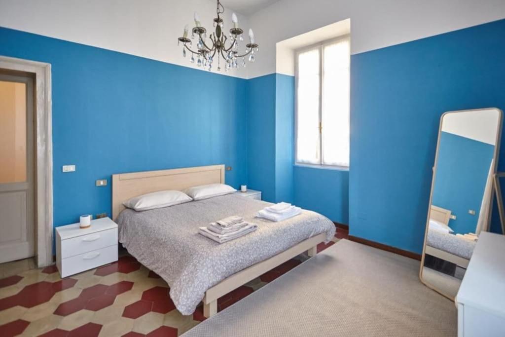 una camera da letto blu con un letto e uno specchio di La Casa Accanto 32 a Brescia