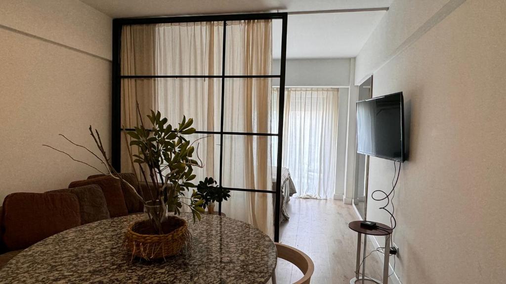 a living room with a table and a tv and a room at MC Apartments Recoleta - Guido in Buenos Aires