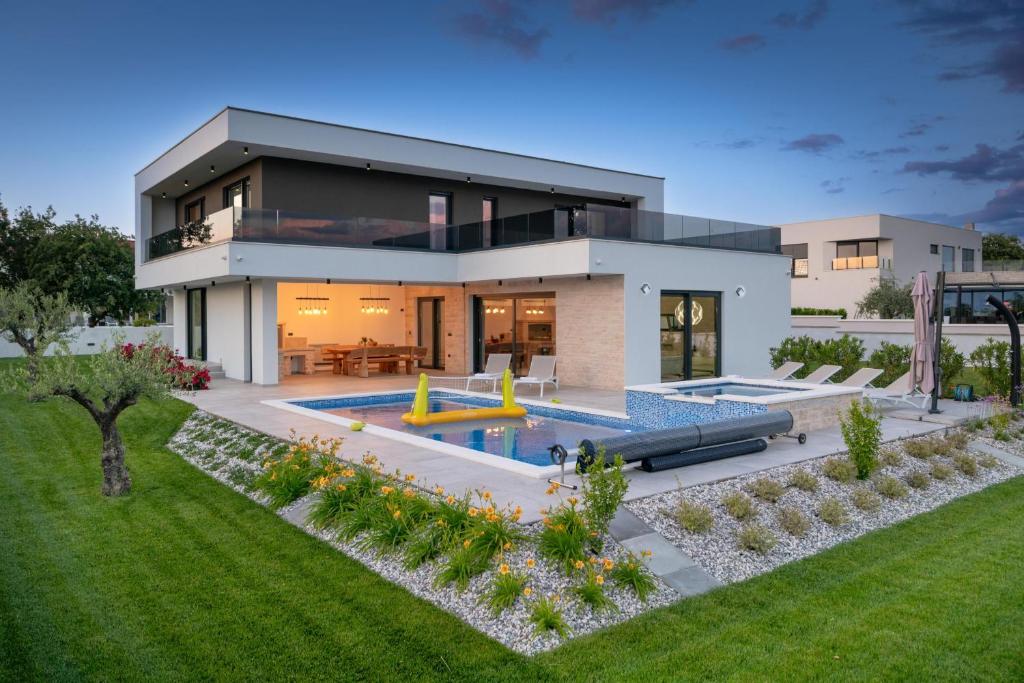 a house with a swimming pool and a backyard at Villa MaEm in Juršići