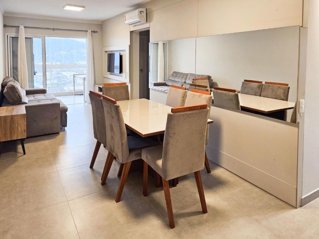 a kitchen with a table and chairs in a room at Apto Climatizado c/ Sacada e Churrasqueira KN0522 in São Francisco do Sul