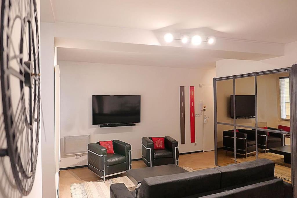 a living room with a couch and chairs and a tv at Appart chic vieux nice 3 min de la plage in Nice