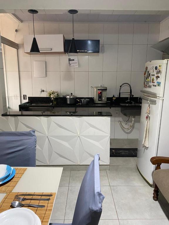 a kitchen with a refrigerator and a counter top at Apartamento 102 até 9 pessoas com garagem in Ipatinga
