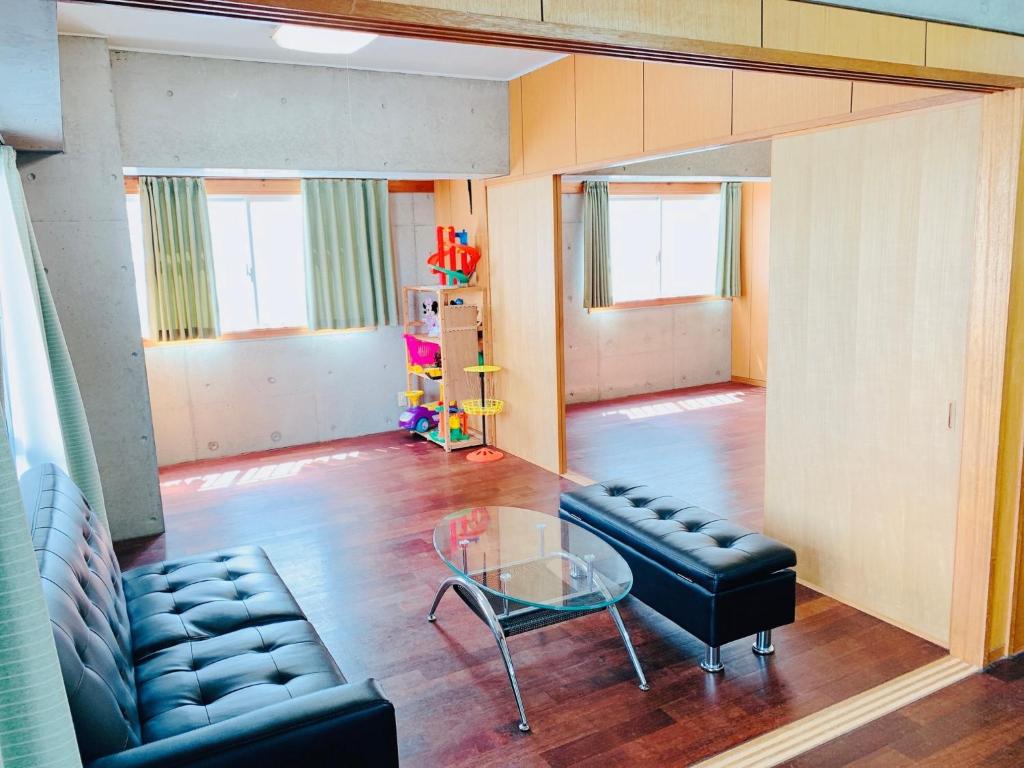 a living room with a couch and a glass table at Guest House Terrace Sakashita - Vacation STAY 46666v in Naha