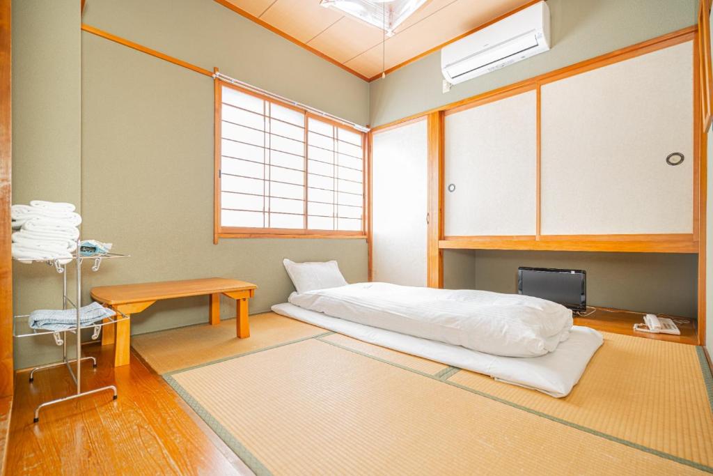 a room with a bed and a table and a window at Fujiminoyado - Vacation STAY 62036v in Gotemba