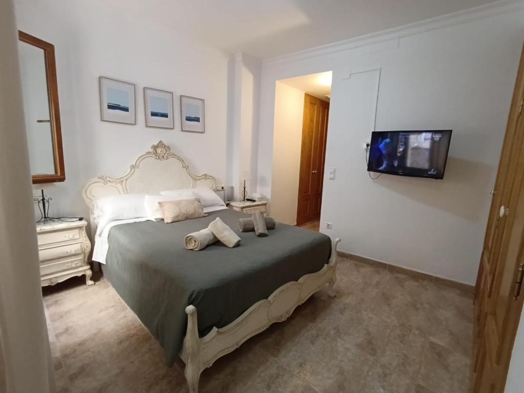 a bedroom with a large bed with a tv on the wall at Casa Purissima 31 in Benissa