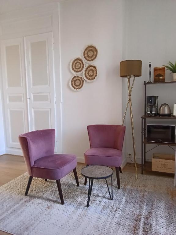 - deux chaises violettes et une table dans le salon dans l'établissement Appartement sur la route touristique du champagne, à Sézanne