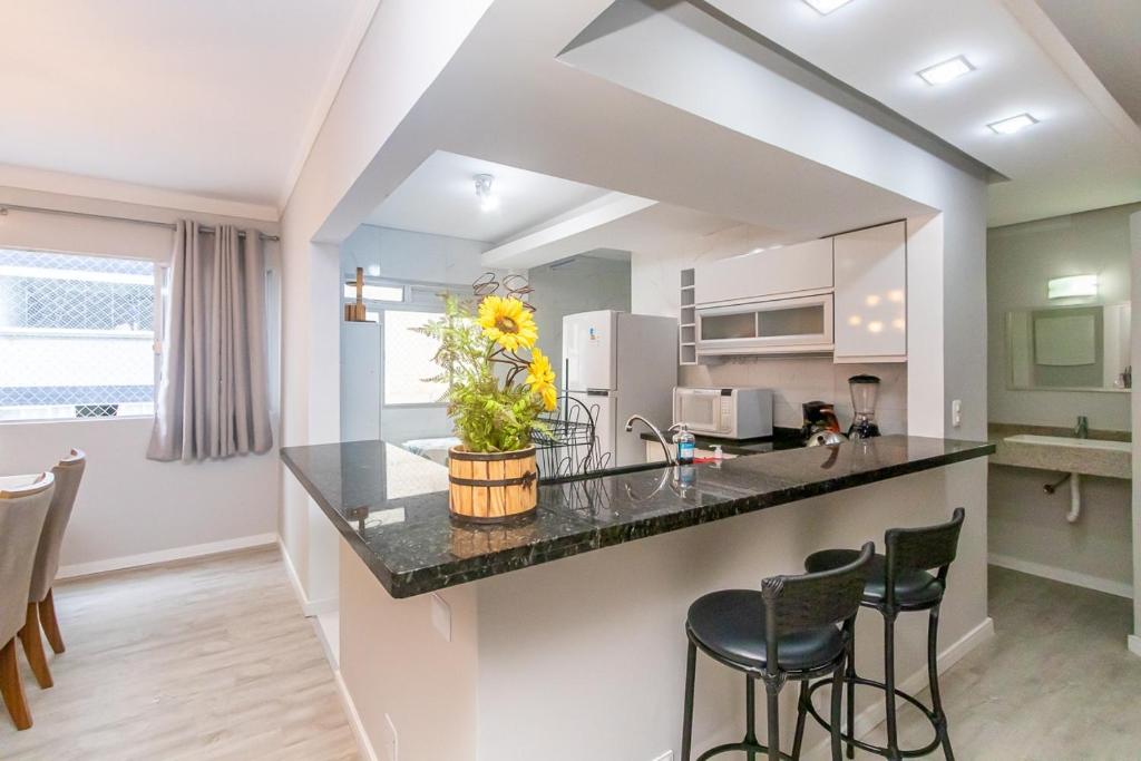 una cucina con un bancone e sgabelli in una stanza di Apto Pe na Areia, direcao Ilha-Balneario Camboriu. a Balneário Camboriú