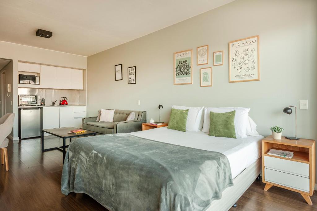 een slaapkamer met een groot bed en een keuken bij High End Cozy Apt at CENTRAL RECOLETA -Amazing View- powered by Argenhost 12H in Buenos Aires