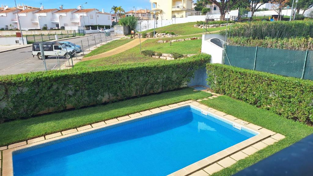 una vista aérea de una piscina azul con césped en Apartamento Olhos do Mar, en Olhos de Água