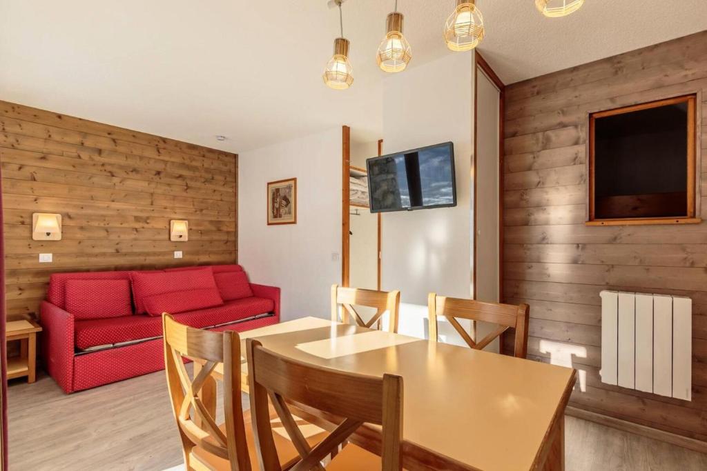 un salon avec une table et un canapé rouge dans l'établissement Résidence Agate - Résidence AGATE N°19 MAE-5221, à Aime La Plagne