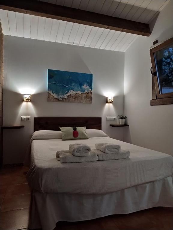 a bedroom with a large bed with towels on it at El Vivero in Chiclana de la Frontera