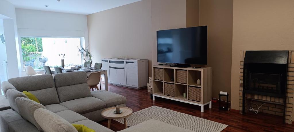 a living room with a couch and a flat screen tv at La villa Duchesse proche de Malo les Bains in Dunkerque