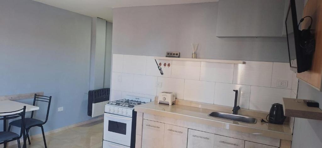 a small kitchen with a stove and a sink at Departamento rivadavia in Perito Moreno