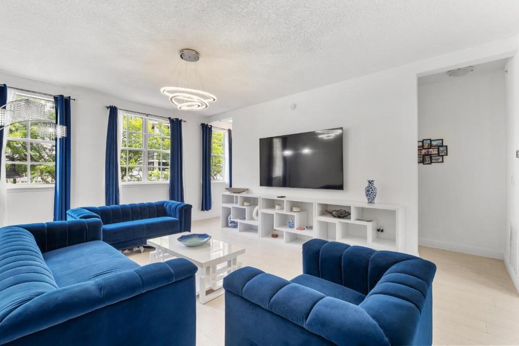 a living room with blue couches and a tv at Bayside Townhome - Private Beach Access, Pool and Hot Tub, Free Parking in Golden Isles
