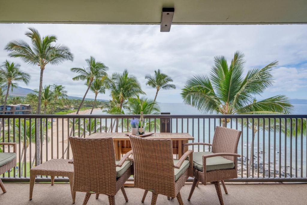 a table and chairs on a balcony with a view of the ocean at Mana Kai 501 in Wailea