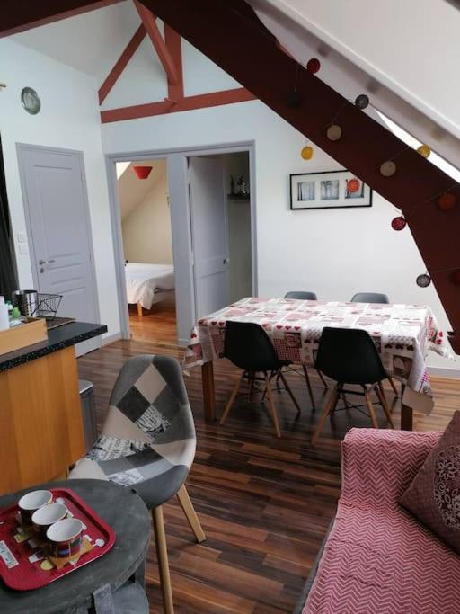 un salon avec une table et des chaises dans une pièce dans l'établissement Appartement calme à 300 m de la plage-centre ville - Quiet appartment 300 m near city and beach, à Mers-les-Bains