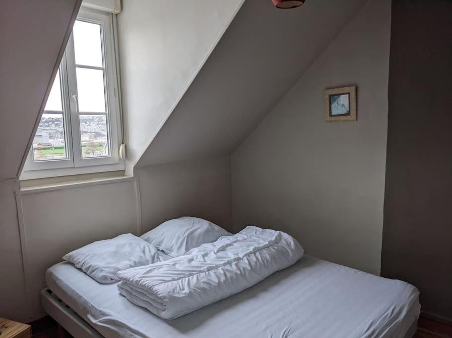 Bett mit weißer Bettwäsche in einem Zimmer mit Fenster in der Unterkunft Appartement calme à 300 m de la plage-centre ville - Quiet appartment 300 m near city and beach in Mers-les-Bains