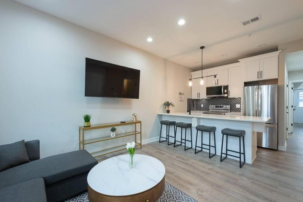 a living room and kitchen with a couch and a table at Modern LUX 2BR Apartment in DC with Patio in Washington