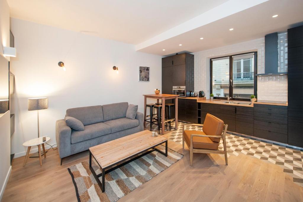 パリにあるPick A Flat's Apartment in Le Marais - Rue Sainte Croix de la Bretonnerieのリビングルーム(ソファ、テーブル付)
