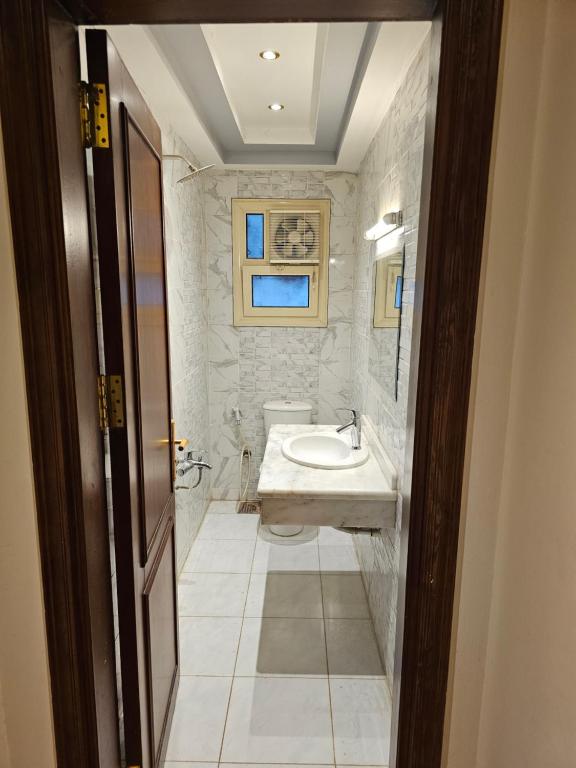 a white bathroom with a sink and a tub at cute apartment in Cairo