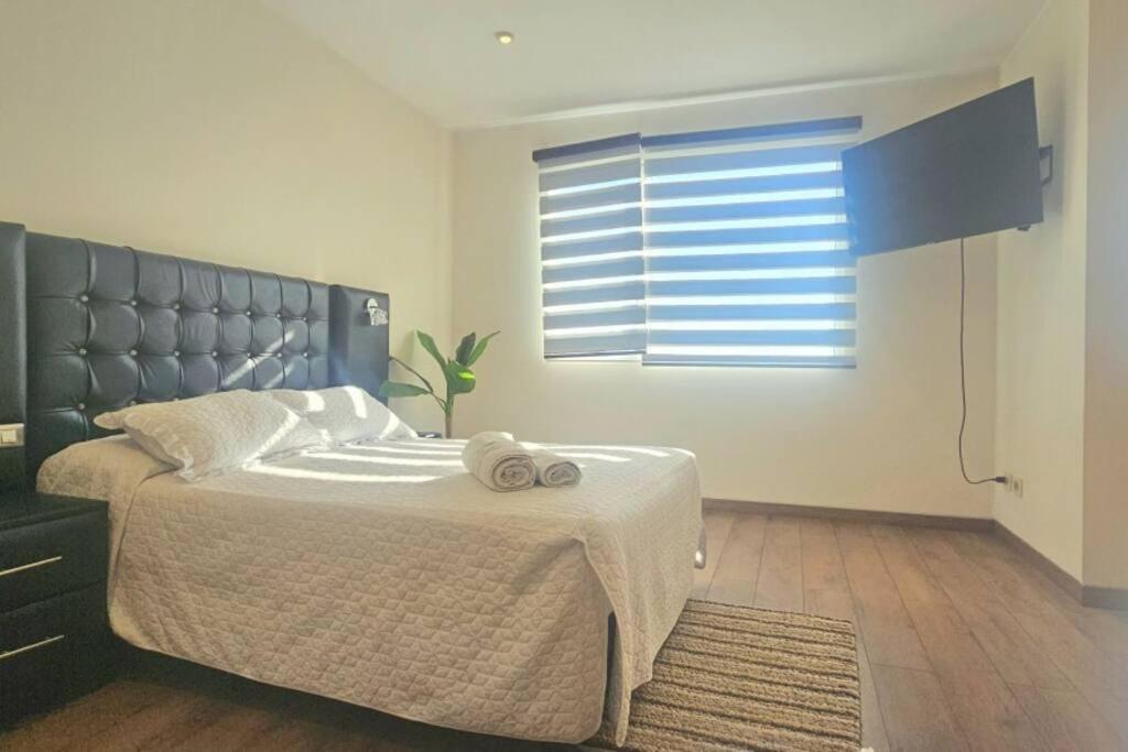 a bedroom with a large bed and a window at Comodo y equipado departamento en la Av Juan de la Rosa in Calacala