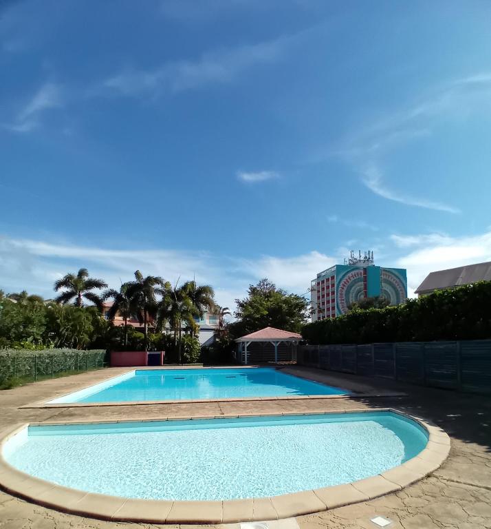 a large swimming pool in a resort at Au bout du rêve - Le Gosier in Le Gosier