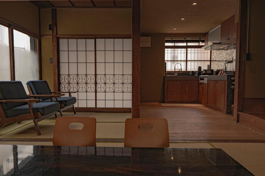 a living room with two chairs and a kitchen at CraftFlat Asakusa House in Tokyo