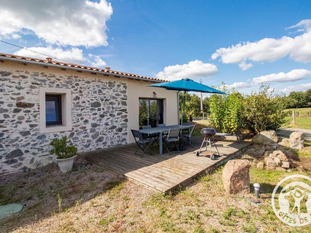 a patio with a table and an umbrella at Gîte moderne et confort, proche Puy du Fou, Nantes, Cholet, terrasse, pêche à l'étang privé - FR-1-622-42 in La Renaudière