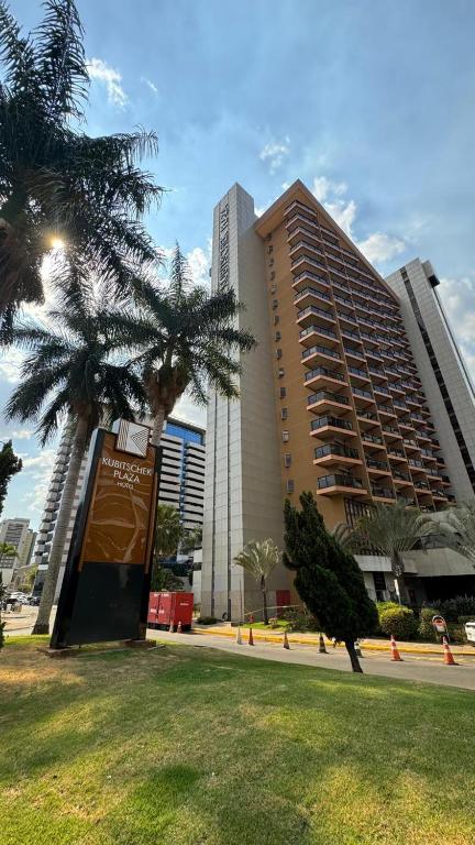 a large building with a palm tree in front of it at KUBITSCHEK - JK APART Hotel in Brasília