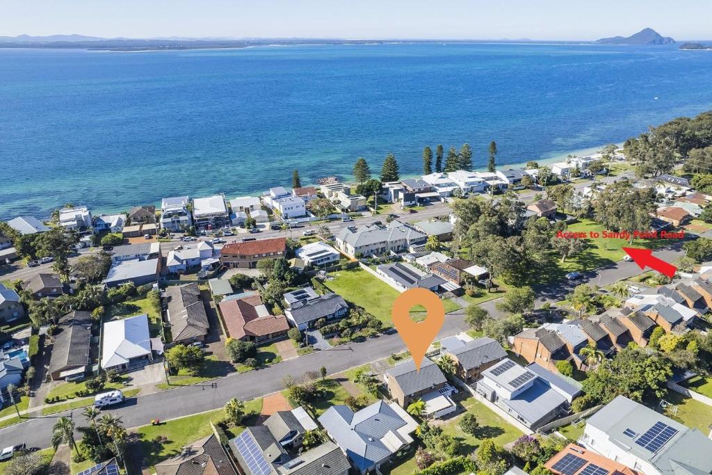 una vista aérea de un suburbio residencial con una flecha roja en Hanks Corlette House, 49 Pantowora St - pet friendly, air con, boat parking, Wi-Fi, en Corlette