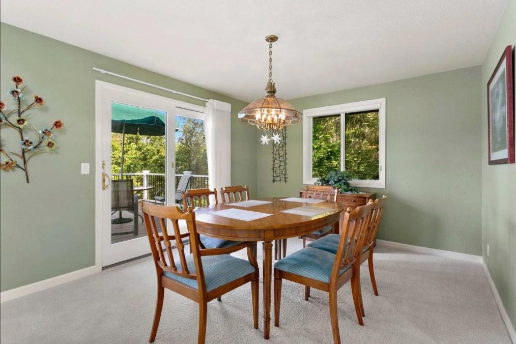 una sala da pranzo con tavolo, sedie e lampadario pendente di Cozy Redmond Retreat- Shared Home near Parks and Attractions a Redmond