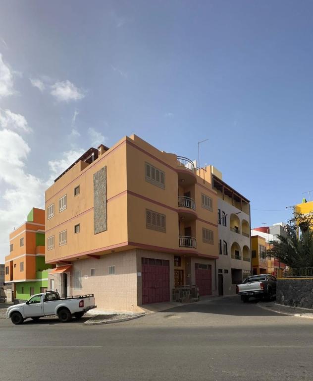 un edificio con un'auto parcheggiata di fronte di Casa Lima a Mindelo