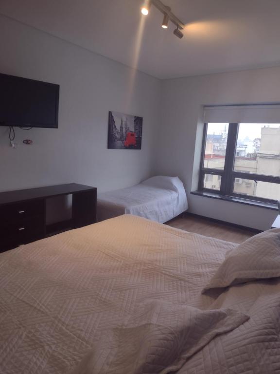 a bedroom with two beds and a tv on the wall at Depto torre Bayres Obelisco in Buenos Aires
