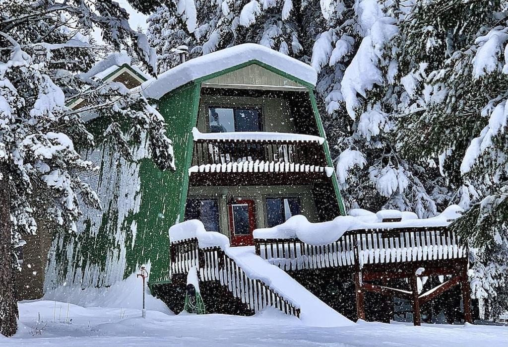 a snow covered house with a snow covered staircase at Yellowstone Cabin in Island Park- King bed with private bathroom and HOT TUB in Island Park