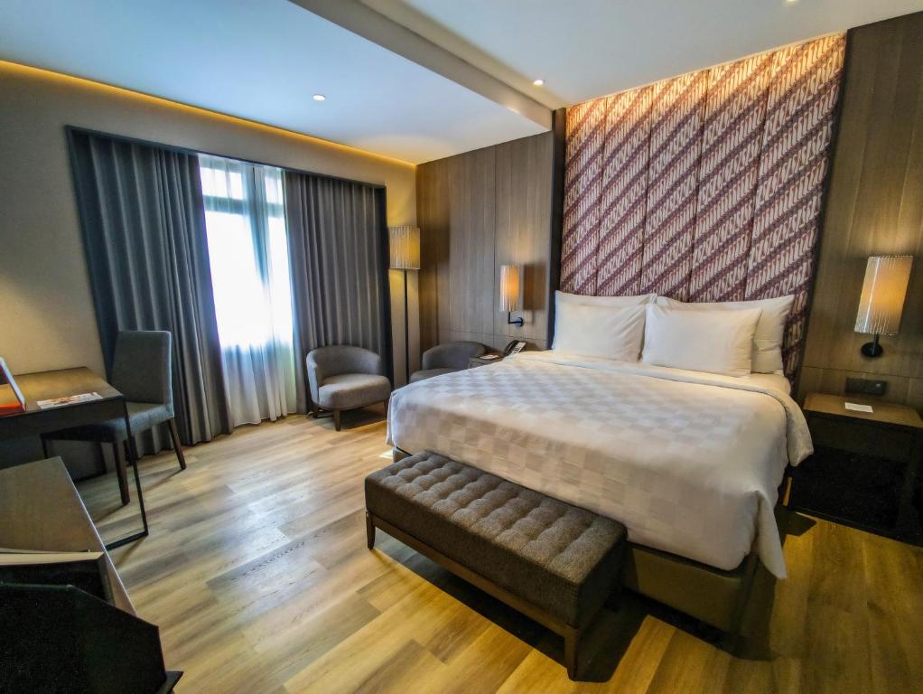 a hotel room with a bed and a desk at Swiss-Belhotel Airport Yogyakarta in Yogyakarta