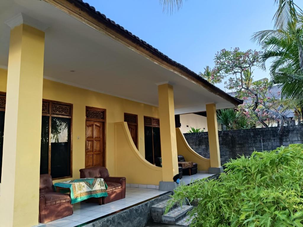 a house with two chairs and a table on a porch at Bungalow Mudri Lovina in Temukus