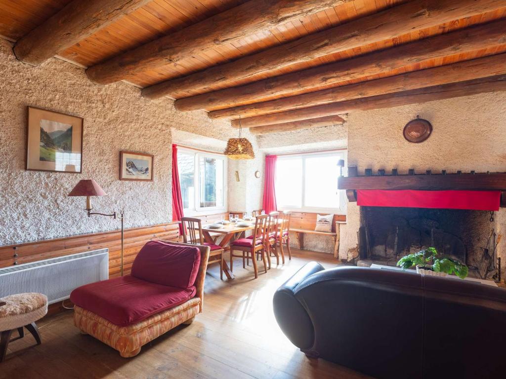 - un salon avec une cheminée, une table et des chaises dans l'établissement Grange authentique à Saint-Lary-Soulan - 5 couchages, cheminée, casier à skis - FR-1-296-502, à Saint-Lary-Soulan