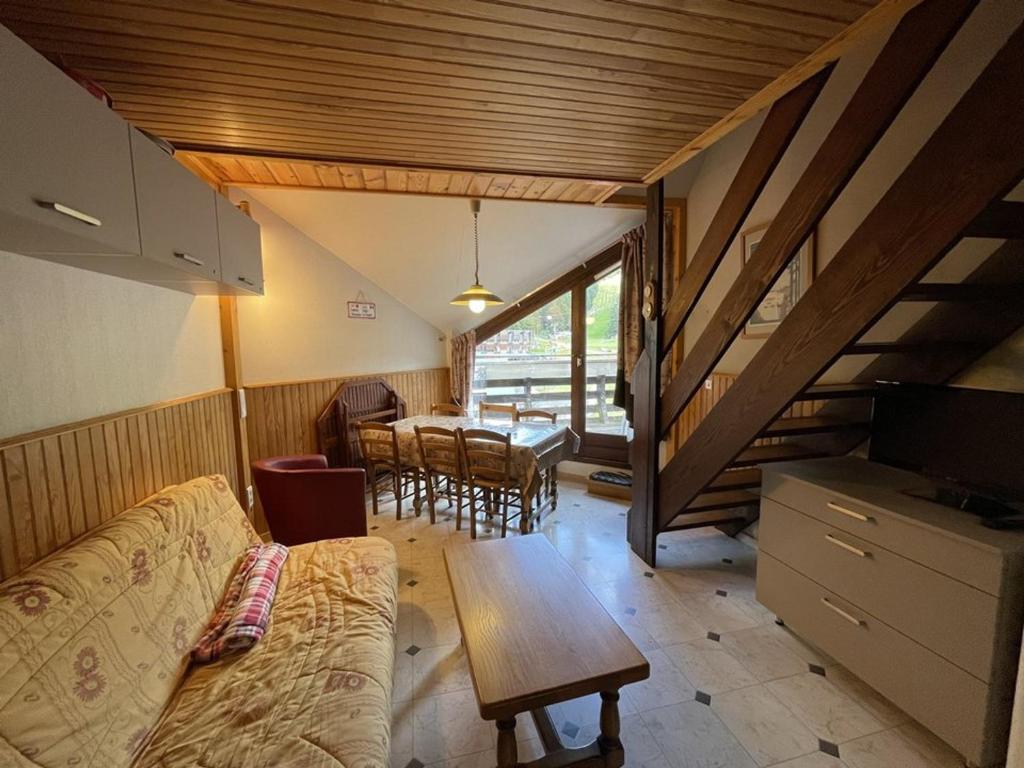 un salon avec un canapé et une table avec des chaises dans l'établissement Duplex moderne avec balcon, proche pistes, 2 chambres - FR-1-787-77, à Laveissière