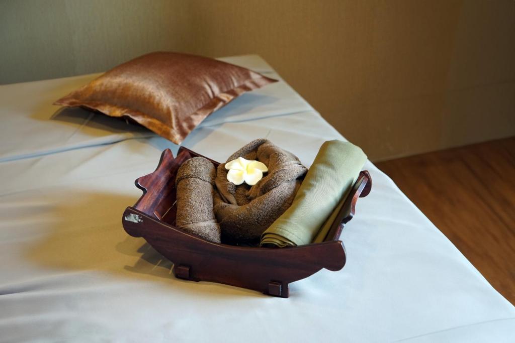 a suitcase on a bed with towels and an umbrella at Swiss-Belhotel Airport Yogyakarta in Yogyakarta